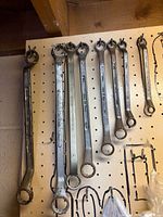 Full view of seven offset wrenches hanging on pegboard