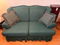Front view of green/teal loveseat with matching pillows