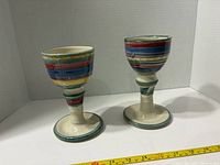 Pair of multicolor striped stoneware goblets front view with measuring tape