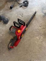 Full view of Homelite corded chainsaw with bar and cord