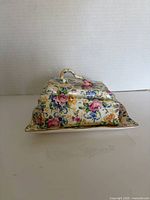 Covered butter dish side view showing floral pattern and handle