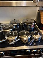 Full set on stovetop showing five pots/pans with lids