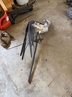 Rooster garden stake lying on floor, showing full stake length and tail