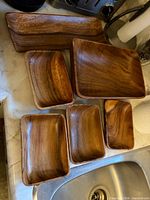 All six wooden trays/bowls laid out to show sizes and condition