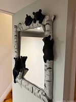 Oblique view of mirror showing birch log frame and bear cub figures