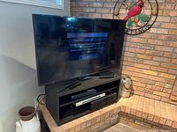 Front view of Samsung 50" TV powered on, on stand