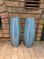 Front view of both matching ribbed light blue iridescent ceramic floor vases