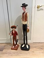 Front view of both cowboy figurines side by side