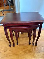 Front view of three mahogany nesting tables stacked
