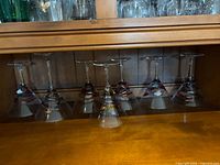 Seven martini glasses inverted on shelf to show full set and stems