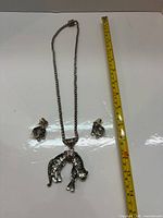 full view of necklace and earrings with measuring tape