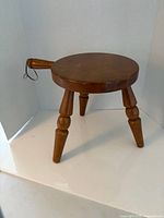 Full view of stool showing seat, legs, and handle