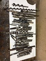 Top view of full grouping of twist and auger bits laid out on board