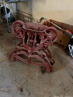 Full view of cast iron hay trolley showing overall form and red paint