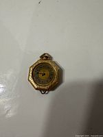Front view of octagonal pocket watch showing dial and case engraving