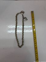 Full bracelet alongside ruler showing length just over 16 inches
