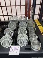 Group shot of assorted glass and crystal candle holders and votives with tall crystal candlestick
