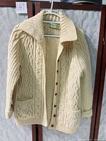 Front view showing overall cardigan design, buttons, pockets, collar