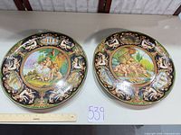 Front view of two Faenza hand-painted wall plates