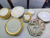 Stacked dinner plates, salad plates, saucers and cups displayed on table
