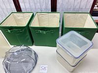 Three green fabric storage cubes lined up open