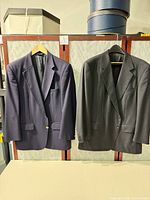Front view of both blazers hanging: navy Burberrys on left, charcoal Ermenegildo Zegna on right