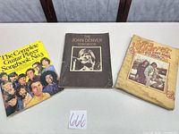 Three songbooks laid flat showing front covers