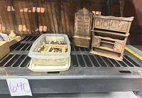 Lot overview showing plastic container of lace bobbins, two wooden miniature cabinets and shelving