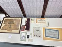 Tabletop overview of all items including frame, tie, plaid square, compass, certificates and ephemera