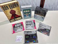 Group shot showing paperback, Ludlum CDs, Follett boxed set