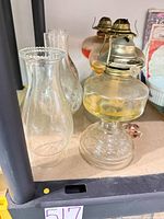 Two lamps with etched glass bases, ribbed fonts, brass burners, removed chimneys visible