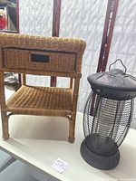 Nightstand front view with drawer and shelf alongside solar bug zapper lamp