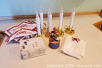 Overview of lot showing five candles, music box, carol booklets and napkins