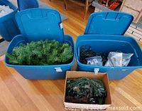 Two blue totes and cardboard box showing garland and lights
