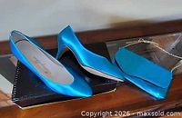 Pair of blue satin pumps on shoebox with matching clutch