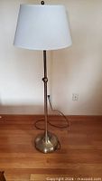 Full view of lamp showing brass base, pole, shade, and cord