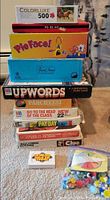 Full stack of board games, puzzle on top, loose pieces bag in foreground