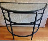 Front view of demi-lune console showing metal frame and glass shelves