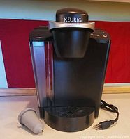 Front view of Keurig brewer showing body, water tank, power cord, and reusable filter