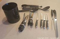Entire lot laid out including utensil holder, utensils, bundled knives, individual knives and carving fork