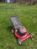 Front-left view of red Craftsman push mower showing deck, engine cover and front wheels