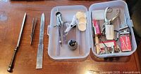 Letter openers, tweezers and open box showing compass, stamp, stapler, clips