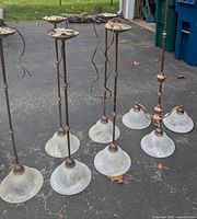Set of five single pendants and one three-arm fixture laid on driveway
