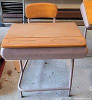 Front view of one desk showing wood top, metal frame, attached seat