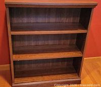 Front view of wood bookcase showing three shelves