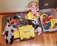 Overview of entire lot showing Fisher-Price house, plush toys, Domino Rally pieces in bin