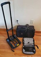 Travel bag, folded luggage carrier, open toiletry bag on floor