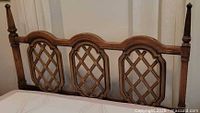 Front view of wooden headboard showing three lattice panels