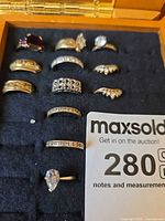 Ten 14k gold rings arranged in display slot