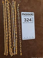 All seven gold pieces with lot card for scale and identification